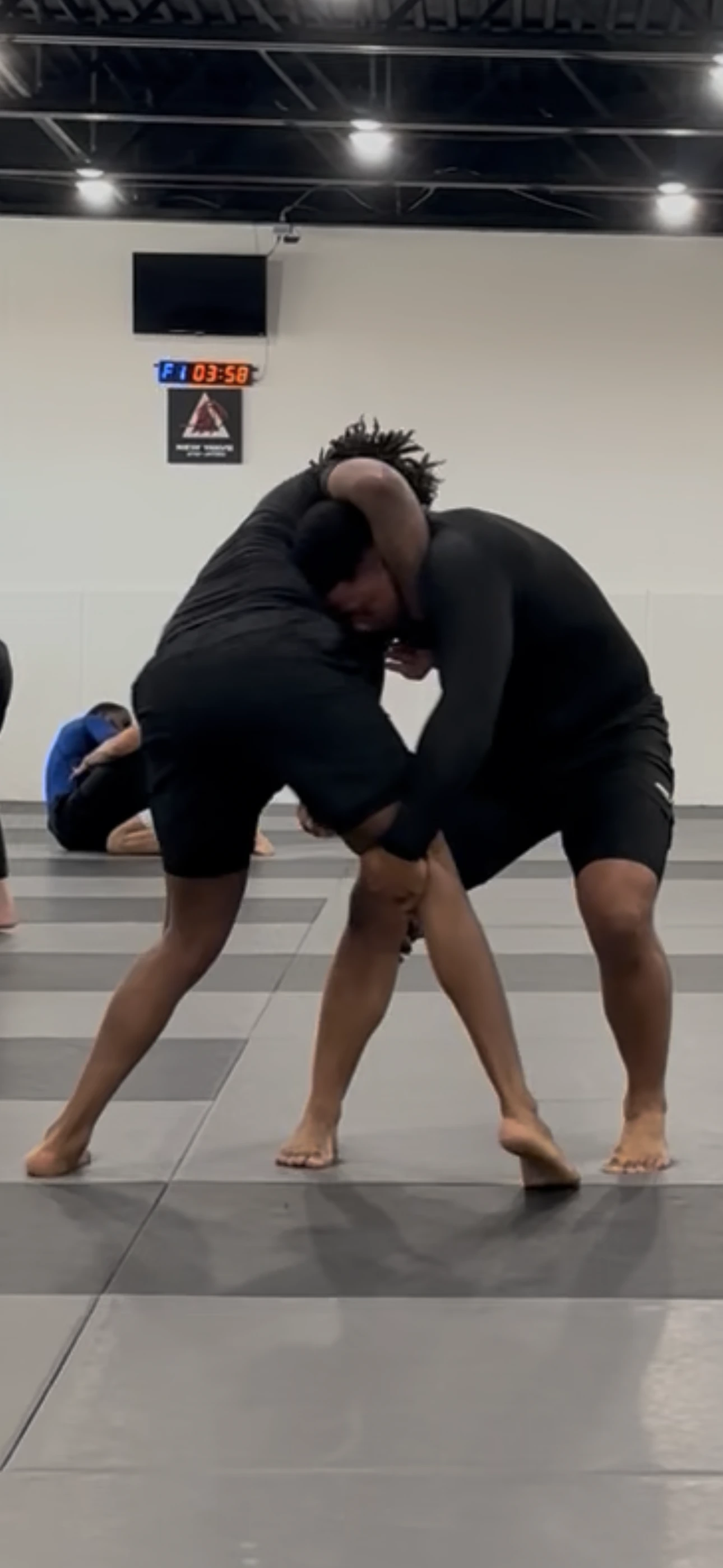 A no-gi rolling session on the mats