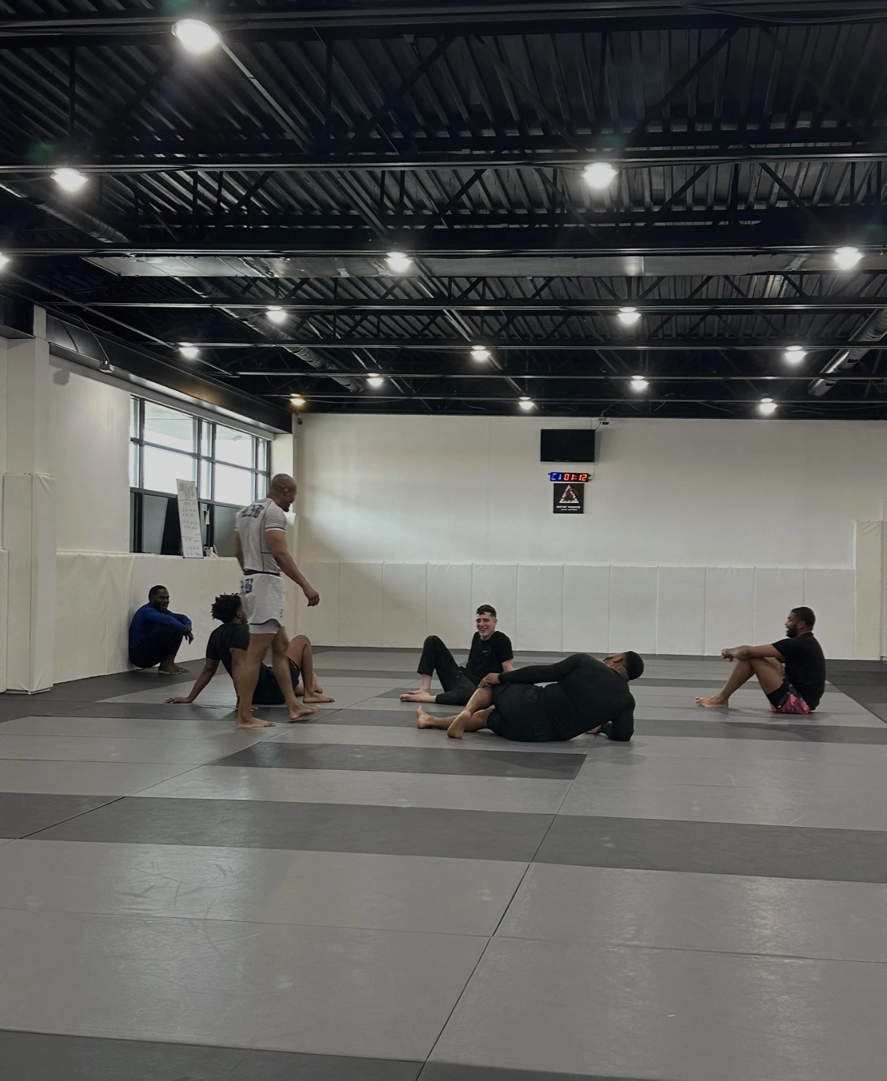 Adults training no-gi Jiu-Jitsu, controlling position on the ground