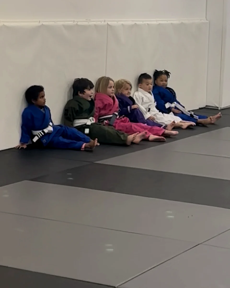 Kids practicing Jiu-Jitsu together on the mats