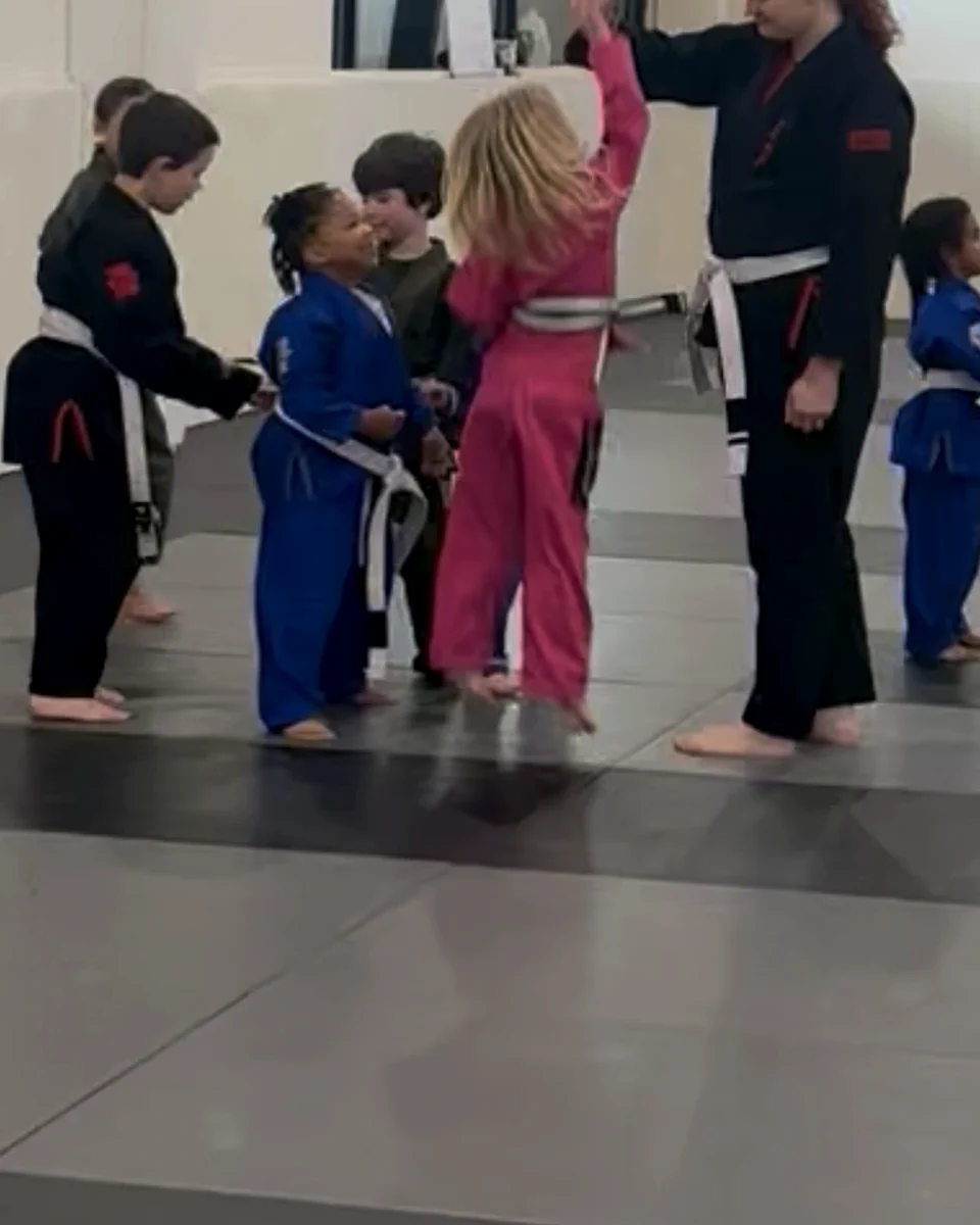 Coach high-fiving a young student after class